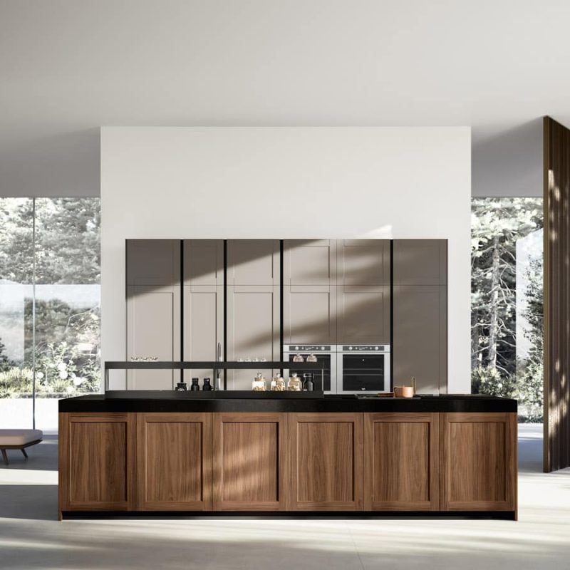 Cuisine moderne avec îlot central en bois, façades métalliques grises et grandes baies vitrées sur jardin