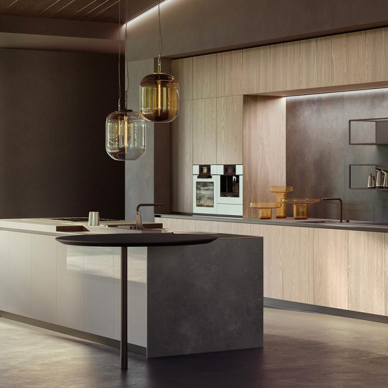 Cuisine moderne avec îlot central noir, armoires en bois clair, suspensions dorées et appareils électroménagers intégrés