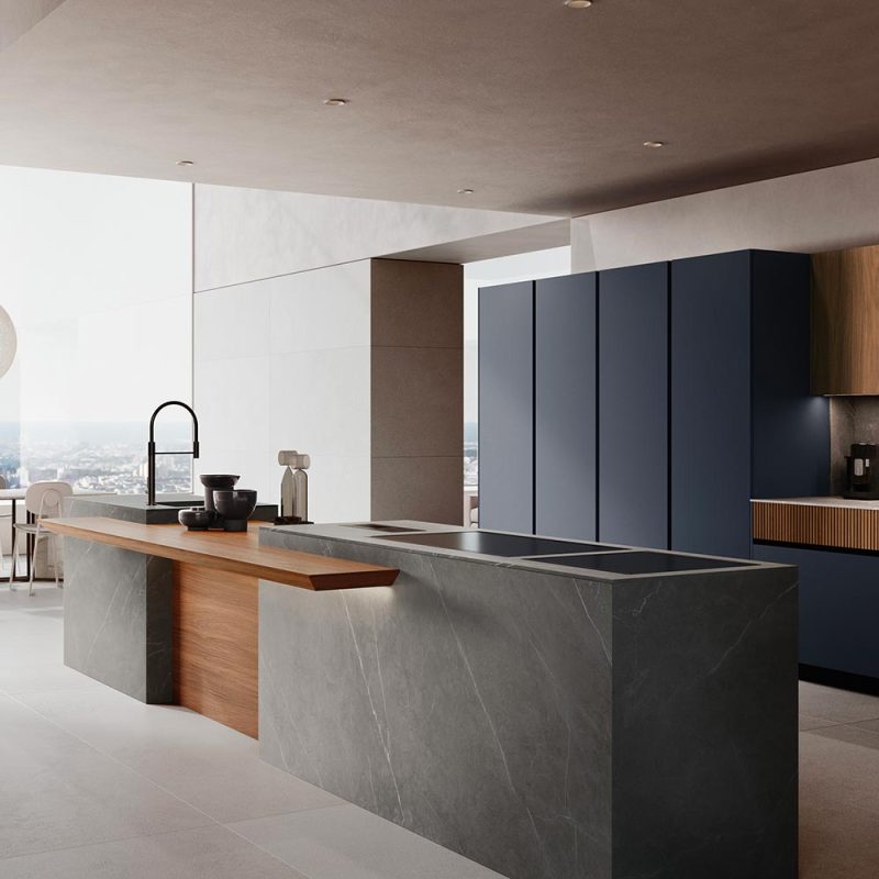 Cuisine moderne avec îlot central en marbre gris, façades bleues et bois, plafond suspendu et éclairage intégré