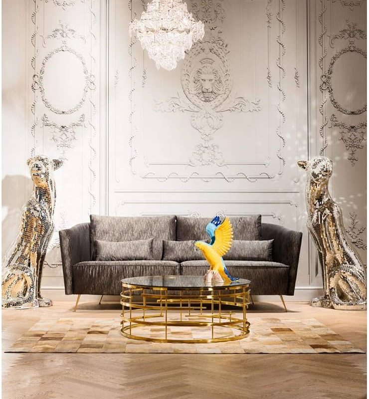 Salon de luxe avec canapé gris, léopards dorés décoratifs, lustre cristal et murs ornementés de style classique français